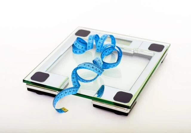 Imagem de uma calculadora com uma fita métrica